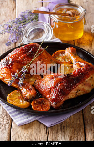 Cuisse de poulet frites fraîches avec du miel de lavande, d'épices et de citron sur une plaque sur une table verticale. Banque D'Images