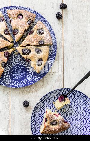 Gâteau Blackberry saupoudrée de sucre glace, un morceau coupé Banque D'Images
