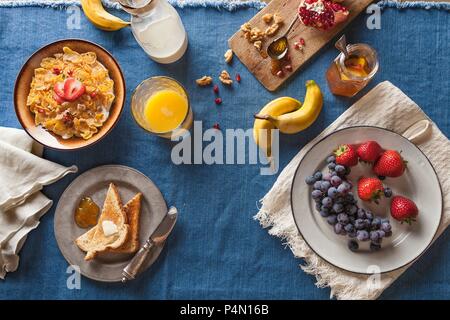 Buffet petit-déjeuner, céréales, fruits, pain grillé et jus d'Orange Banque D'Images