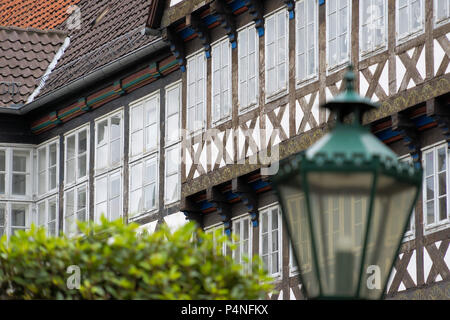 Façade d'une maison à colombages dans une vieille ville, avec une lanterne et floue délibérément un flou de la Couronne les arbres en premier plan, Allemagne Banque D'Images