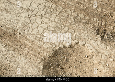 Sur la trace de roue sur le sol Des traces .du tracteur, pelle, voiture, automobile les traces de pneus sur la piste boueuse. La texture, l'arrière-plan Banque D'Images