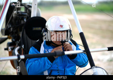 Yinchuan, Chine. 23 juin 2018. Liu Yibing met sur un casque avant de décoller à son aéroclub en comté Helan de Yinchuan City, dans le nord-ouest de la Chine, région autonome du Ningxia Hui, 21 juin, 2018. Liu Yibing, 46 ans, est né dans une famille de paysans. À l'âge de 17 ans, il a été inspiré pour faire un avion ultra-léger par lui-même après lecture d'un magazine de l'aviation. Source : Xinhua/Alamy Live News Banque D'Images