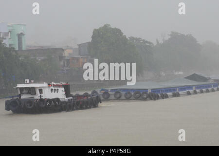 Mandaluyong City, région de la capitale nationale, aux Philippines. 23 mai, 2018. Après une chaude journée de nuages de pluie a commencé à se former et, en quelques minutes, le ciel soudainement drop. Les gens se mettre à l'eau sur la route.Ce remorqueur bateau le long de la rivière Pasig tout en tirant sa lourde charge. Crédit : George Buid/ZUMA/Alamy Fil Live News Banque D'Images