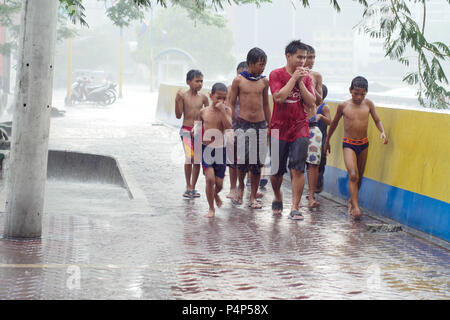 Mandaluyong City, région de la capitale nationale, aux Philippines. 23 mai, 2018. Après une chaude journée de nuages de pluie a commencé à se former et, en quelques minutes, le ciel soudainement drop. Les gens se mettre à l'eau sur la route.Alors que le soleil est un sommet hors de l'pluie nuages ces groupe d'enfants a décidé de marcher sur le trottoir par la rivière Pasig et humide. Crédit : George Buid/ZUMA/Alamy Fil Live News Banque D'Images