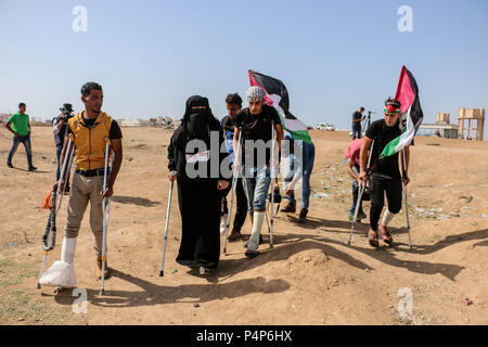 Gaza, la Palestine. 22 Juin, 2018. Manifestants blessés vu marchant près de la ligne de front.Les affrontements entre les civils palestiniens et soldats israéliens ont éclaté de nouveau à la frontière de la bande de Gaza et Israël près du site de Nahal Oz est de la ville de Gaza. Les forces israéliennes ont blessé de nombreux civils palestiniens en tirant des balles réelles et des grenades lacrymogènes pour le manifestant qui sont à l'intérieur de leur propre territoire.Les Palestiniens protestent contre le transfert de l'ambassade américaine à Jérusalem et à la reconnaissance de Jérusalem comme capitale d'Israël par le président américain Donald Trump. (Crédit Image : Banque D'Images