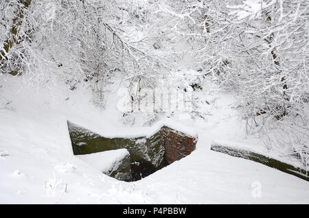 Bunker sous de vieux murs de brique en hiver après les chutes de neige . Banque D'Images