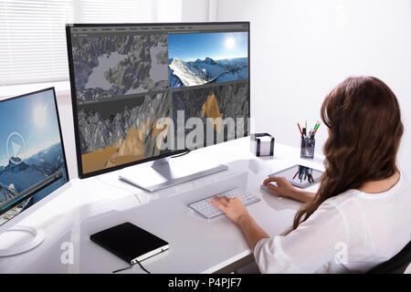 Vue arrière d'une femme travaillant sur le paysage 3D computer in Office Banque D'Images