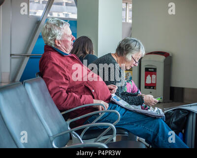 Les passagers assis sur des chaises et d'attente dans le hall des départs de l'aéroport de Melbourne. Melbourne, Victoria Australie Banque D'Images