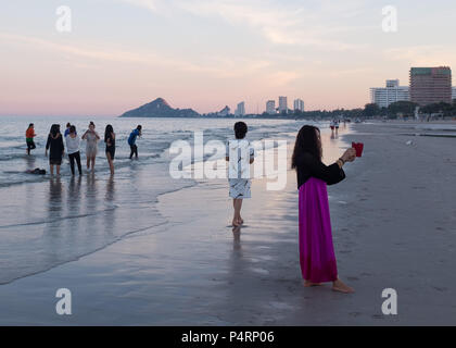 Les femmes qui prennent des photos sur la plage au soir, Prachuap Khiri Khan Province, Hua Hin, Thaïlande, Asie. Banque D'Images