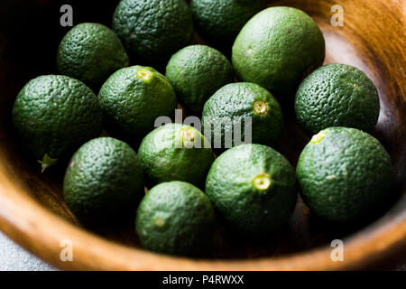 Vert Vert immature Limes dans bol en bois. L'alimentation biologique. Banque D'Images