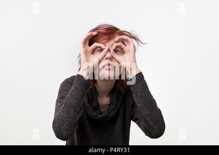 Portrait de femme assez informel inhabituelle avec la coiffure colorés par des lunettes imaginaires faits de doigts. Essayer de voir les petits détails ou s Banque D'Images