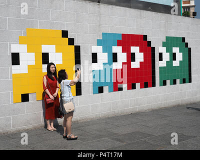 Voir des touristes de prendre un en selfies avant d'un art de la mosaïque par l'artiste français Invader d'infiltration à Hong Kong Banque D'Images