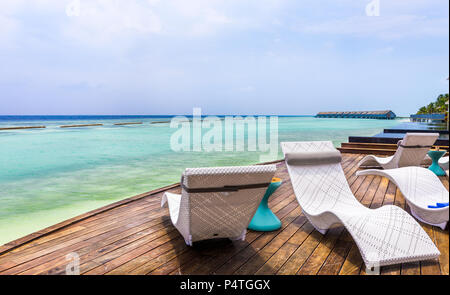 Chaise longue et belle turquoise de l'océan Indien en Maldives Banque D'Images