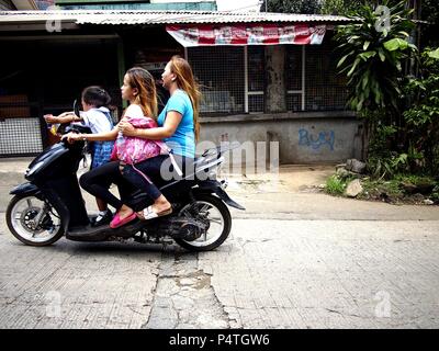 ANTIPOLO CITY, PHILIPPINES - le 18 juin 2018 : deux femmes et une petite fille la moto à un Uphill road. Banque D'Images