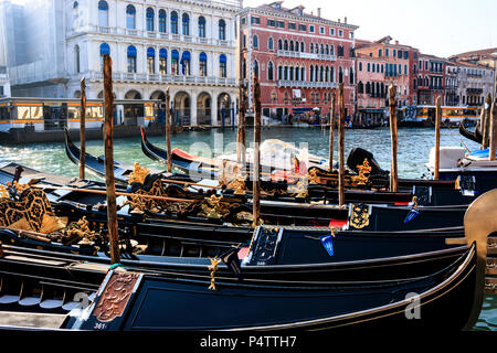 Un lumineux matin de Venise avec un groupe de gondoles bleu amarré ensemble sur le Grand Canal de palais dans l'arrière-plan, Rialto, Venise, Italie. Banque D'Images