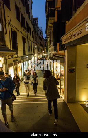 Nuit foule touristique promenade et shopping par vitrine glow, Venise, Italie. Banque D'Images