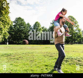 Heureux père fille portant sur les épaules dans un parc Banque D'Images