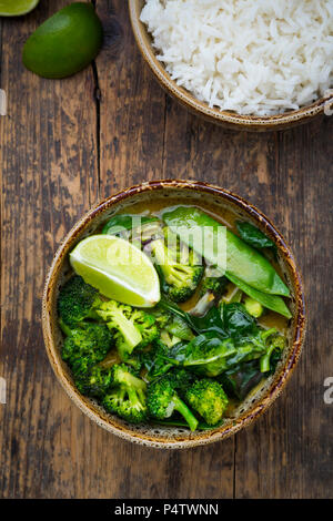 Le curry thaï vert avec brocoli, pak choi, pois mange-tout, épinards, lime et bol de riz Banque D'Images