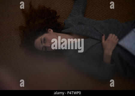 Portrait of a young woman lying on the carpet Banque D'Images