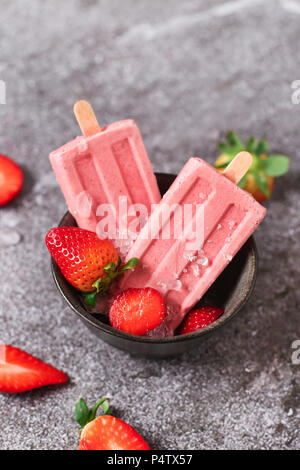 Des sucettes glacées aux fraises dans des bols Banque D'Images