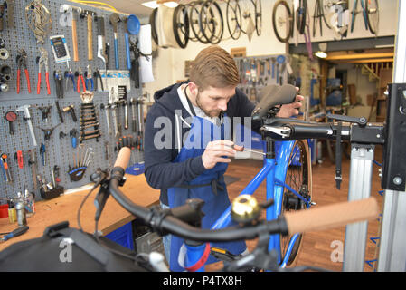 Mécanicien vélo travaillant dans son atelier de réparation Banque D'Images