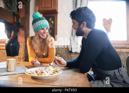 Heureux couple manger en refuge de montagne rustique Banque D'Images