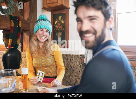 Heureux couple cartes à jouer en refuge de montagne rustique Banque D'Images