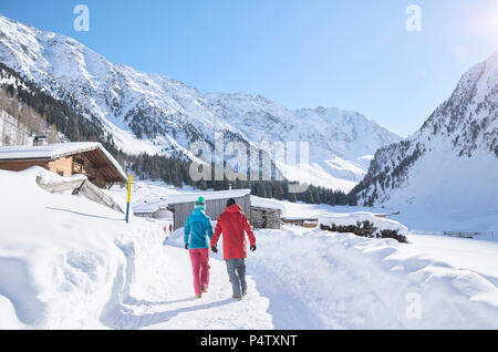 Couple marchant dans un paysage couvert de neige Banque D'Images