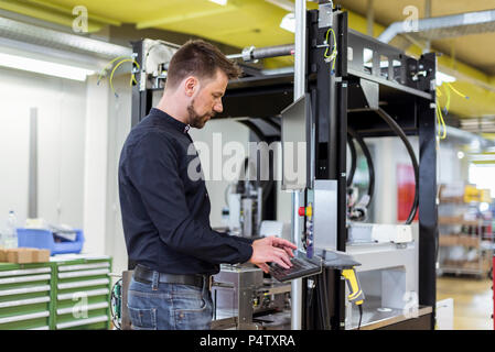 L'homme dans l'utilisation de la machine en usine Banque D'Images