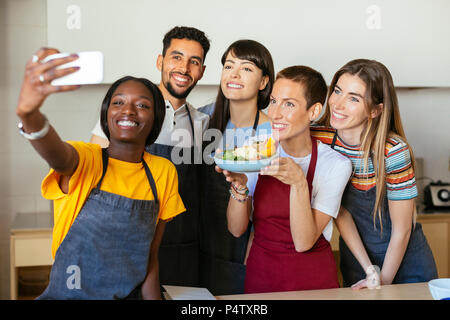 Les amis et l'instructeur dans un atelier de cuisine en tenant un selfies Banque D'Images