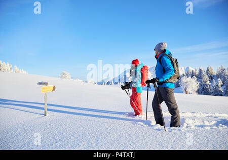 L'Autriche, le Tyrol, la raquette, le couple standing in front of sign post Banque D'Images