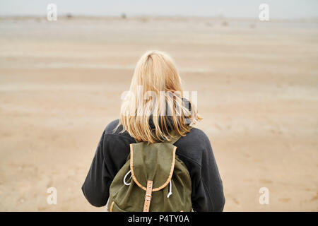 Vue arrière de blonde jeune femme avec sac à dos sur la plage Banque D'Images