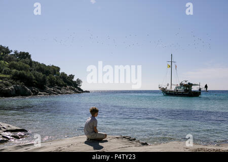 Garçon assis dans une station looking at view Banque D'Images