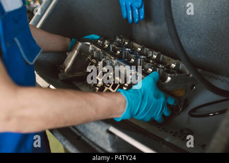 Détail de mécanicien travaillant sur un moteur dans son atelier Banque D'Images