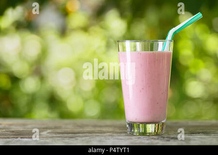 Milkshake rose dans le verre sur la table Banque D'Images