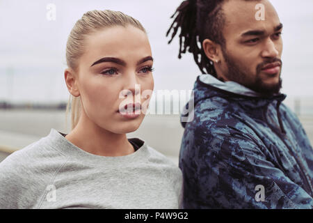 Jeune couple divers dans les vêtements de sport à l'extérieur ensemble après une course sur l'image Banque D'Images