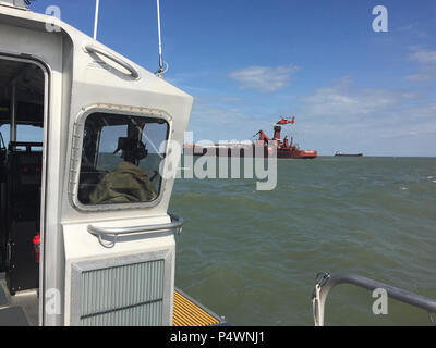 Un bateau de sauvetage de l'équipage de la station de la Garde côtière canadienne Marblehead, Ohio, observe qu'un hélicoptère MH-65 Dolphin à partir de la Air Station Detroit plane sur le cargo Joseph H. Thompson dans inférieur du lac Érié près de London le 10 mai 2017. L'opérateur du navire a demandé de l'aide d'évacuer un équipage expérimentez la vie en danger. Banque D'Images