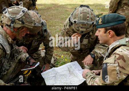 Des soldats britanniques d'Imprimeur Royal Hussars bref mouvements tactiques tout en menant un travail de planification de la mission à la jonction 17 Sabre Hohenfels Domaine de formation, l'Allemagne, le 9 mai 2017. Sortie 17 Sabre est l'armée américaine Europe's Cavalry Regiment 2d centre de formation de combat de l'exercice de certification, qui aura lieu au Centre de préparation interarmées multinationale à Hohenfels, Allemagne, Avril 25-Mai 19, 2017. L'exercice a pour but d'évaluer l'état de préparation du régiment pour mener des opérations terrestres unifiée, avec un accent particulier sur les répétitions de la transition de garnison pour les opérations de combat, et l'exercice Banque D'Images