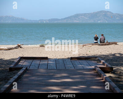 Conduisant à l'arrière de la plate-forme avec un couple assis sur un journal et profiter de la vue de la baie de San Francisco Banque D'Images