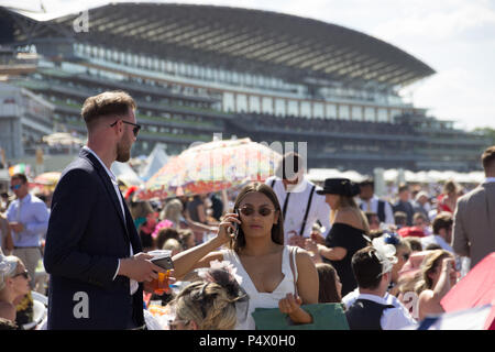 Dame en foule sur téléphone mobile à Ascot Racecourse avec boîtier Queens en arrière-plan Banque D'Images