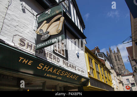 Ville de Canterbury, Angleterre. Shop et de pub sur les fronts du Canterbury Boucherie Lane, avec la Cathédrale de Canterbury's Harry Bell Tower en arrière-plan. Banque D'Images