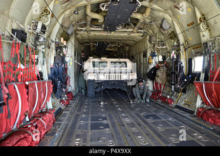 HUNTER LIGGETT, Californie (9 mai 2017) - aviateurs affecté à la 146e escadre aérienne de l'Air National Guard préparer pour décharger une Humvee affectés à la construction navale (bataillon Mobile NMCB) 4 au cours d'un exercice de formation sur le terrain (FTX) à Fort Hunter Liggett, Californie, le 9 mai. NMCB 4 procède à leur classement final de l'exercice de formation sur le terrain (FTX), test de l'élément de commandement, de contrôle et les fonctions de communication grâce à une variété de scénarios réels rencontrés pendant les déploiements. Le bataillon Seabee donne aux commandants et commandants de composante marine avec prêtes au combat warfighter capa Banque D'Images