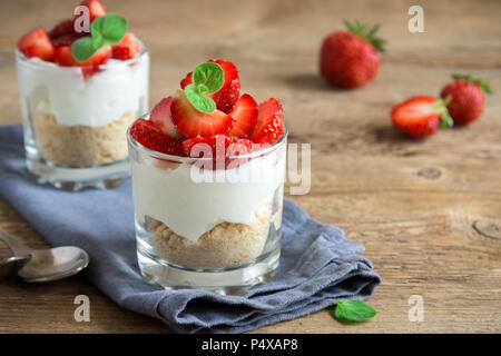 Bagatelle aux fraises dessert mini dans les verres avec des fraises fraîches et fromage à la crème sur fond de bois. Maison saine potrion dessert. Banque D'Images