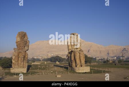 Colosses de Memnon. Statues en pierre représentant le pharaon Amenhotep III (14ème siècle avant J.-C.) en position assise. Vue panoramique. Dix-huitième dynastie. Nouveau Royaume. Luxor. L'Égypte. Banque D'Images