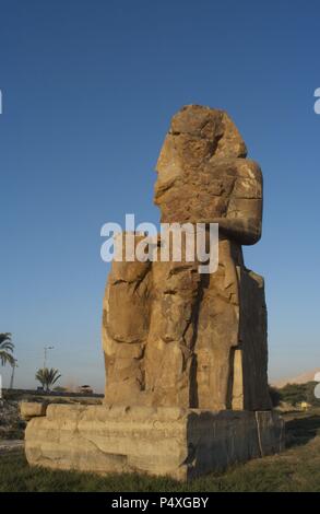 Colosses de Memnon. Statues en pierre représentant le pharaon Amenhotep III (14ème siècle avant J.-C.) en position assise. Le colosse de l'Ouest. Dix-huitième dynastie. Nouveau Royaume. Luxor. L'Égypte. Banque D'Images