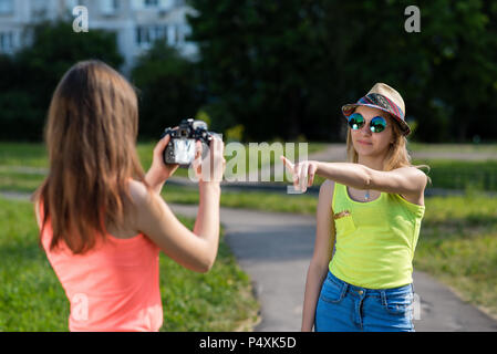 Deux amies. L'été dans la nature. Enregistre la vidéo. Ecolières sur changer faire des photos. Sourit joyeusement. Vous pouvez Concept. Banque D'Images