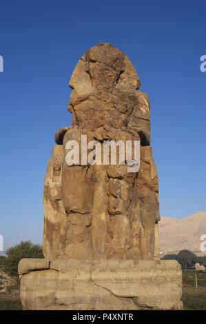 Colosses de Memnon. Statues en pierre représentant le pharaon Amenhotep III (14ème siècle avant J.-C.) en position assise. Le colosse de l'Ouest. Dix-huitième dynastie. Nouveau Royaume. Luxor. L'Égypte. Banque D'Images