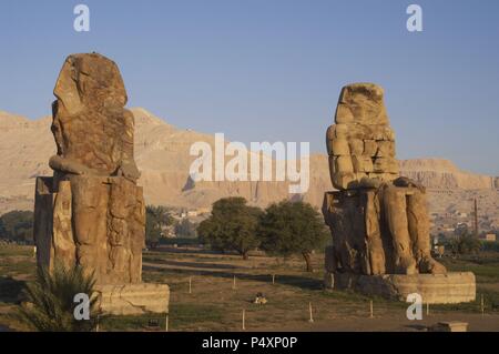 Colosses de Memnon. Statues en pierre représentant le pharaon Amenhotep III (14ème siècle avant J.-C.) en position assise. Vue panoramique. Dix-huitième dynastie. Nouveau Royaume. Luxor. L'Égypte. Banque D'Images