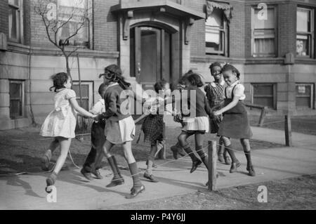 Groupe de filles à l'Ring-Around-a-Rosie sur trottoir dans 'Black Belt' Quartier, Chicago, Illinois, USA, Edwin Rosskam pour Office of War Information, Avril 1941 Banque D'Images