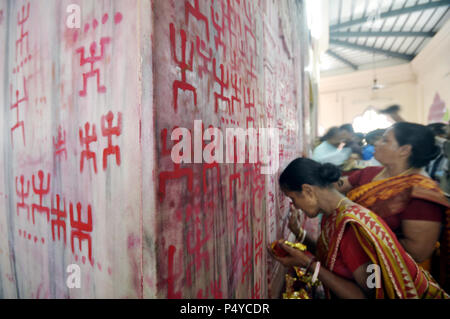 Agartala, Tripura, Inde. Apr 15, 2014. Les femmes indiennes vu le dessin du signe de Sainte Croix gammée au cours de l'Ambubachi.festival le swastika est une figure géométrique et une ancienne icône religieuse qui est tiré de vermillon sur le mur du temple dans le cadre des rituels d'Ambubachi à Agartala, capitale de l'Etat de Tripura, nord-est de l'Inde. Credit : Saha Abishai SOPA/Images/ZUMA/Alamy Fil Live News Banque D'Images